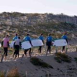 Surfer/-innen auf dem Weg zum Meer